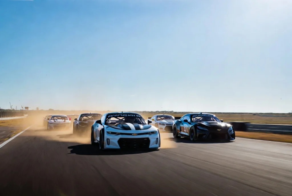 tc-en-toay-2025-02 Pelotón de autos de Turismo Carretera de nueva generación corriendo a alta velocidad en la recta principal durante el TC en Toay 2025, La Pampa.