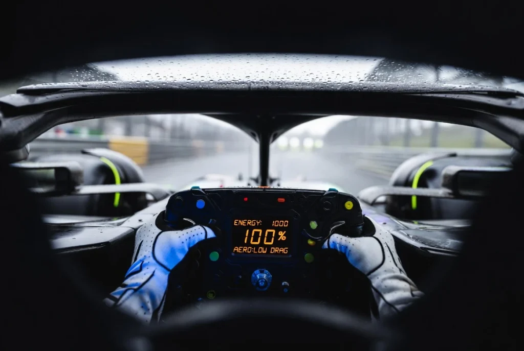 Vista POV desde el casco de un piloto de F1 2026 gestionando la energía y aerodinámica en el volante.